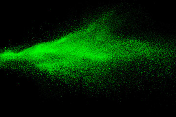 Green color powder explosion cloud  on black background.Green dust splash on dark background.