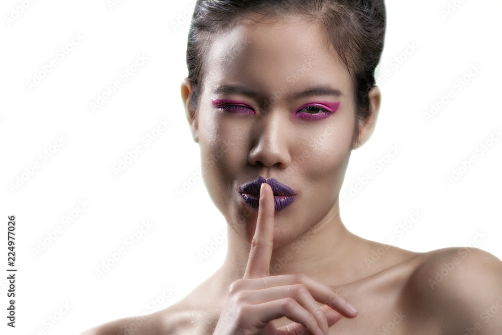 Asian Thai model wears purple lipstick very close shot of mouth and teeth. shot on a white backdrop. she has light brown eyes and pink eye shadow with flower pedals on her face and hair Asian Thai model wears purple lipstick very close shot of mouth and teeth. shot on a white backdrop. she has light brown eyes and pink eye shadow with flower pedals on her face and hair