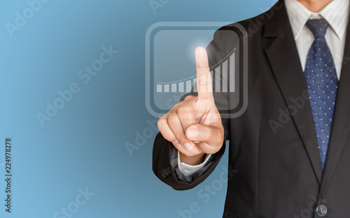 Business man hand touching a graph on blue background, representing business growth