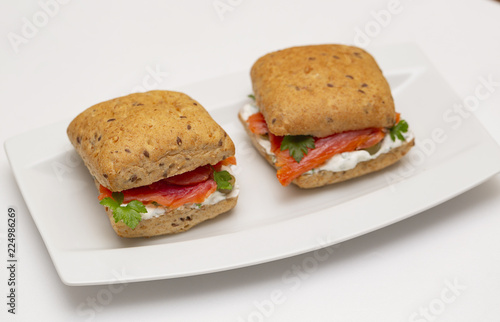 Sandwich with salmon, cheese and cereal bread on white background. Close up.