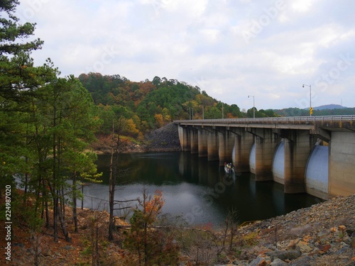 Wide shot of a lake with a bridge at the Beaver’s Bend State Park overlook with the colors of autumn
