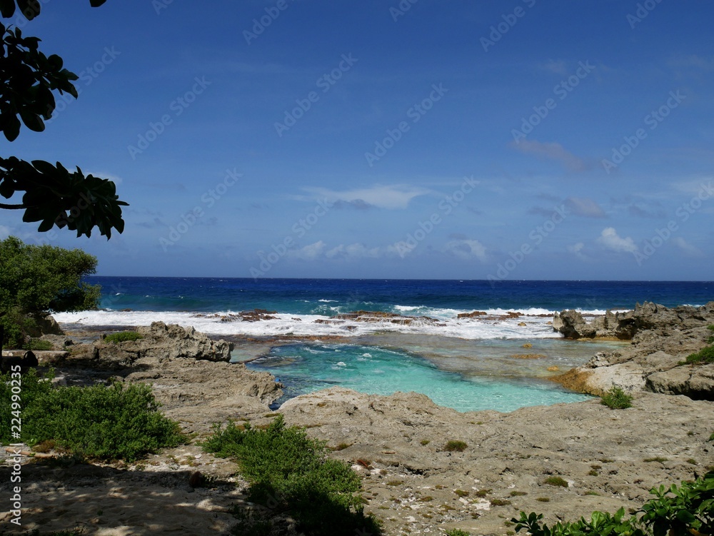 Wide scenic shot of the popular swimming hole in the island of Rota, Northern Mariana Islands on a bright sunny day