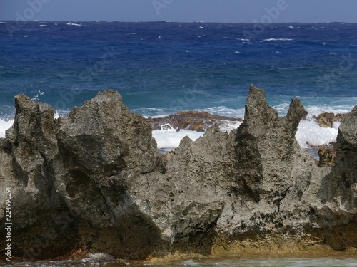 Corals and sharp stones acting as fence to protect a natural pool from direct smashing waves from the ocean in a tropical island 
