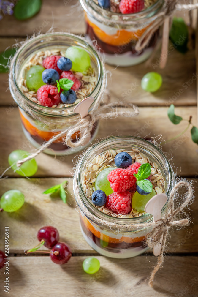 Homemade granola in jar with yoghurt and berry fruits Homemade granola in jar with yoghurt and berry fruits