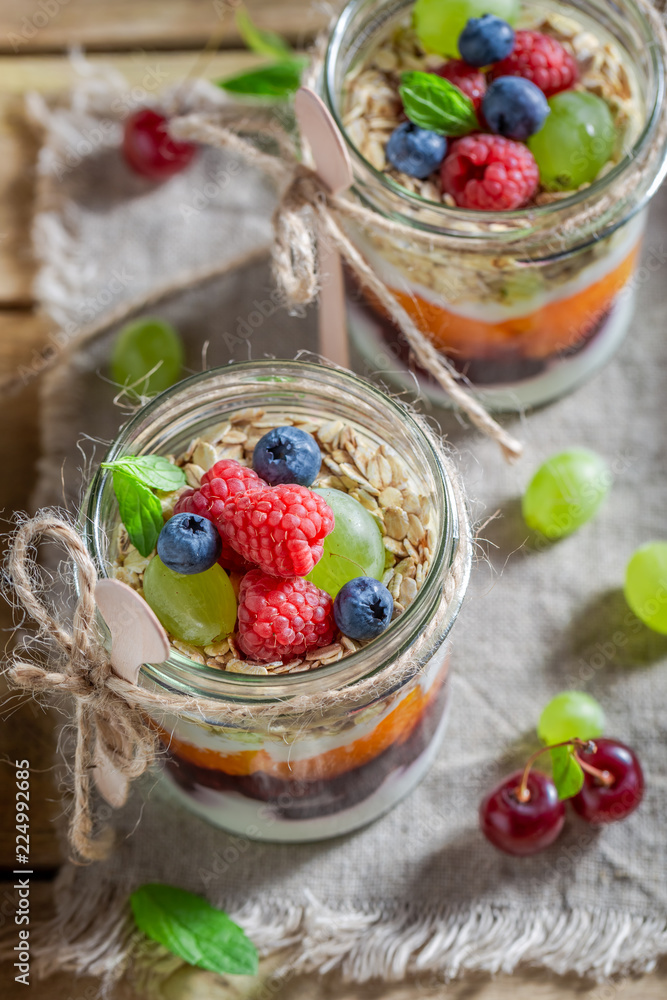 Tasty oat flakes with fresh fruits and yoghurt in jar Tasty oat flakes with fresh fruits and yoghurt in jar