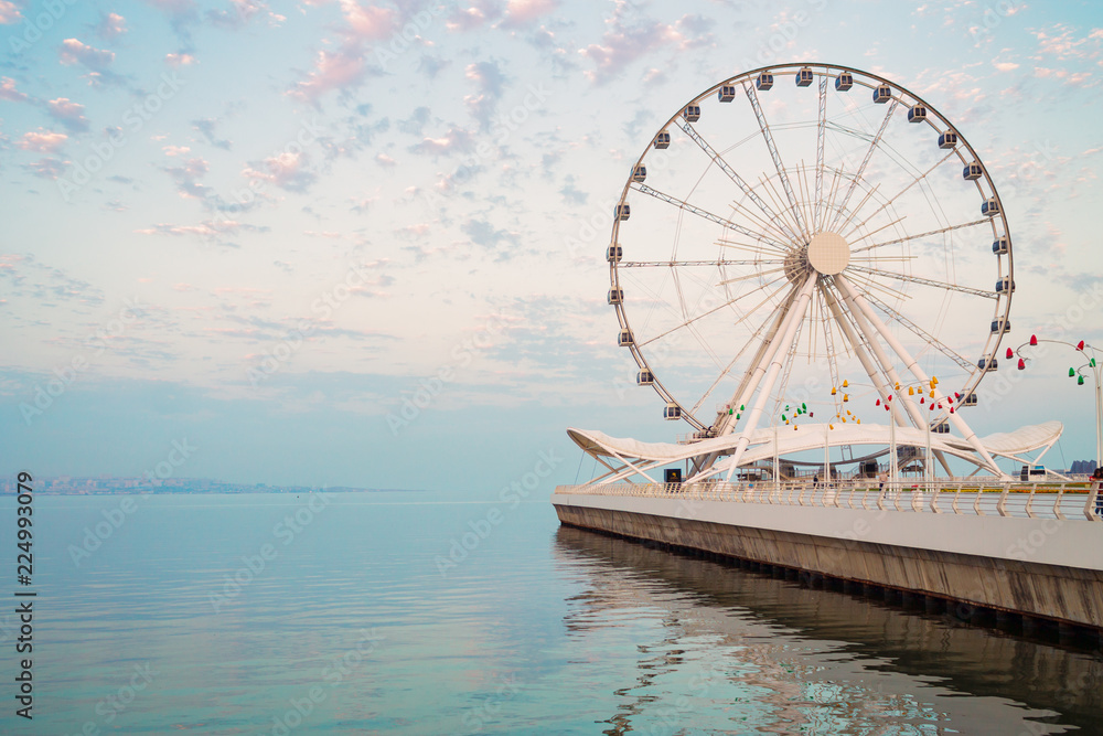 Fototapeta Ferris wheel on waterfront. Big carousel.
