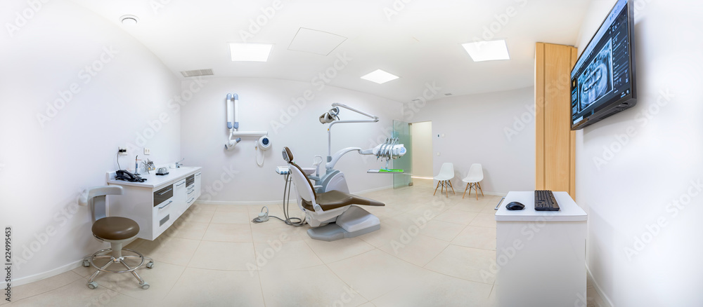Panorama of a clean white modern dentist cabinet with a dental radiography on a screen. Spacious room. Dental care concept. Panorama of a clean white modern dentist cabinet with a dental radiography on a screen. Spacious room. Dental care concept.