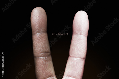 Photography idea showing a black and white finger making a peace sign against racism. photo