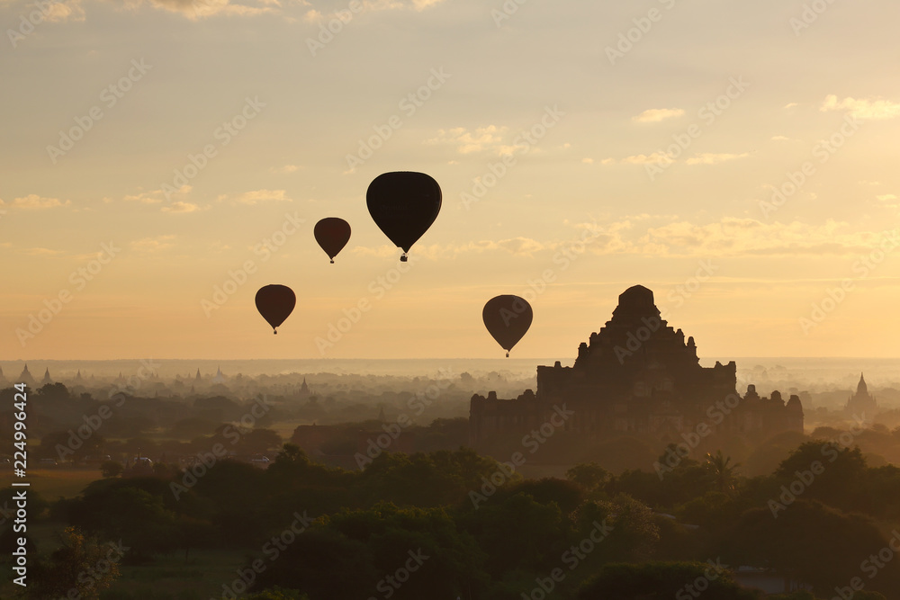 The hot air balloon over plain for tourist and beautiful landscape pagoda ancient with misty morning time of Burma. The landmark tourism culture in Asian. The hot air balloon over plain for tourist and beautiful landscape pagoda ancient with misty morning time of Burma. The landmark tourism culture in Asian.