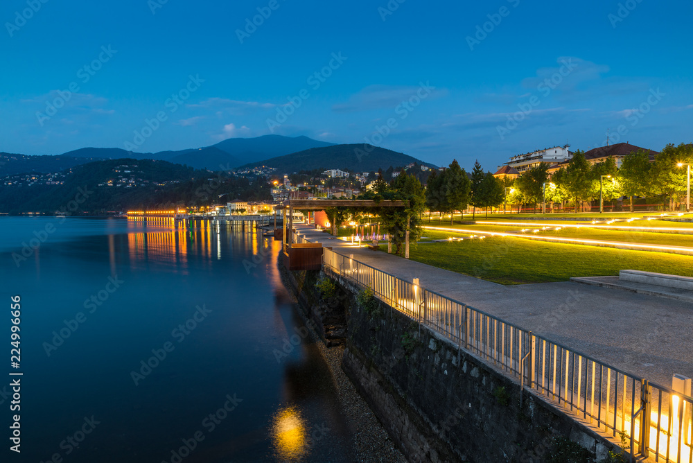 Lakefront promenade at dusk. Lake Maggiore and tourist town of Luino with its beautiful lakefront illuminated on a beautiful summer evening. Big lake in northern Italy