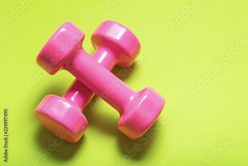 Pair of pink dumbbell on green color