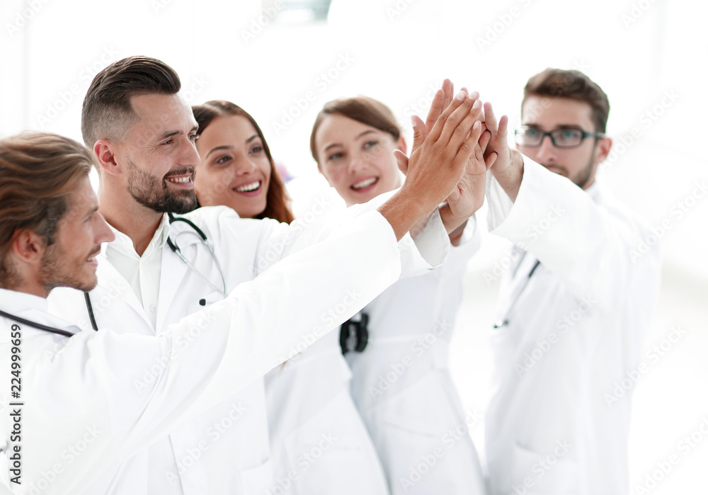 group of doctors giving each other a high five. group of doctors giving each other a high five.