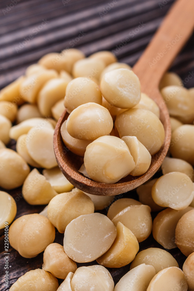 delicious macadamia nuts on a wooden rustic background delicious macadamia nuts on a wooden rustic background