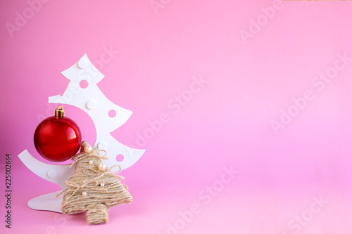 Christmas tree on pastel pink studio background.Holiday festive celebration greeting card with copy space to addng text  photo