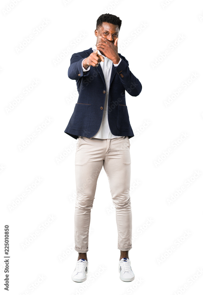 Full body of Handsome african american man wearing a jacket pointing with finger at someone and laughing a lot on white background Full body of Handsome african american man wearing a jacket pointing with finger at someone and laughing a lot on white background