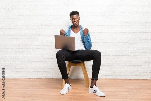 Afro american man working with his laptop celebrating a victory