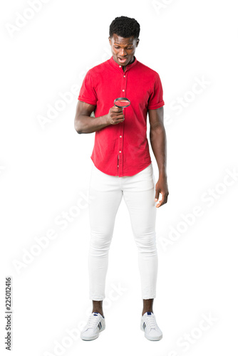 Full body of Young african american man holding a magnifying glass on white background