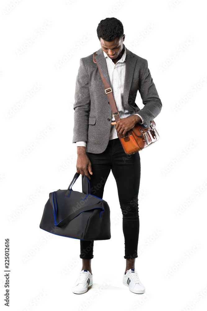 Full body of African american business man traveling with suitcases standing and looking down on white background Full body of African american business man traveling with suitcases standing and looking down on white background