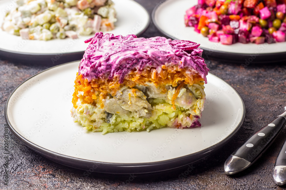 Russian food on dark background. Assortment salad of Russian cuisine - Olivier salad, vinaigrette - beet salad, herring salad. Top view. Copy space. Russian food on dark background. Assortment salad of Russian cuisine - Olivier salad, vinaigrette - beet salad, herring salad. Top view. Copy space.