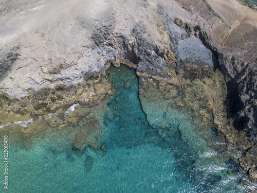 Vista aerea delle coste frastagliate e delle spiagge di Lanzarote, Spagna, Canarie. Bagnanti in spiaggia e nell’Oceano Atlantico. Papagayo