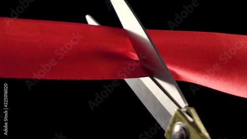 Closeup of red ribbon cutting Slow Motion(isolated on Black background, 4K)