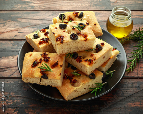 Foto Homemade Italian focaccia with sun dried tomatoes, black olives and rosemary