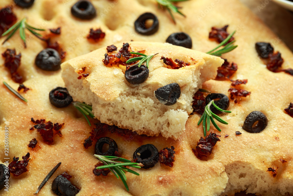 Homemade Italian focaccia with sun dried tomatoes, black olives and rosemary Homemade Italian focaccia with sun dried tomatoes, black olives and rosemary