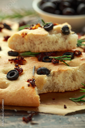 Homemade Italian focaccia with sun dried tomatoes, black olives and rosemary