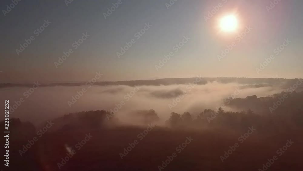 Aerial view of sunrise over fog. Fog in valley view from above. Autumn morning in mountain valley. Aerial view of sunrise over fog. Fog in valley view from above. Autumn morning in mountain valley.