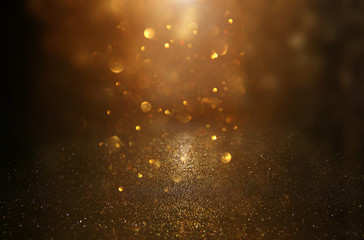 glitter vintage lights background. black and gold. de-focused.