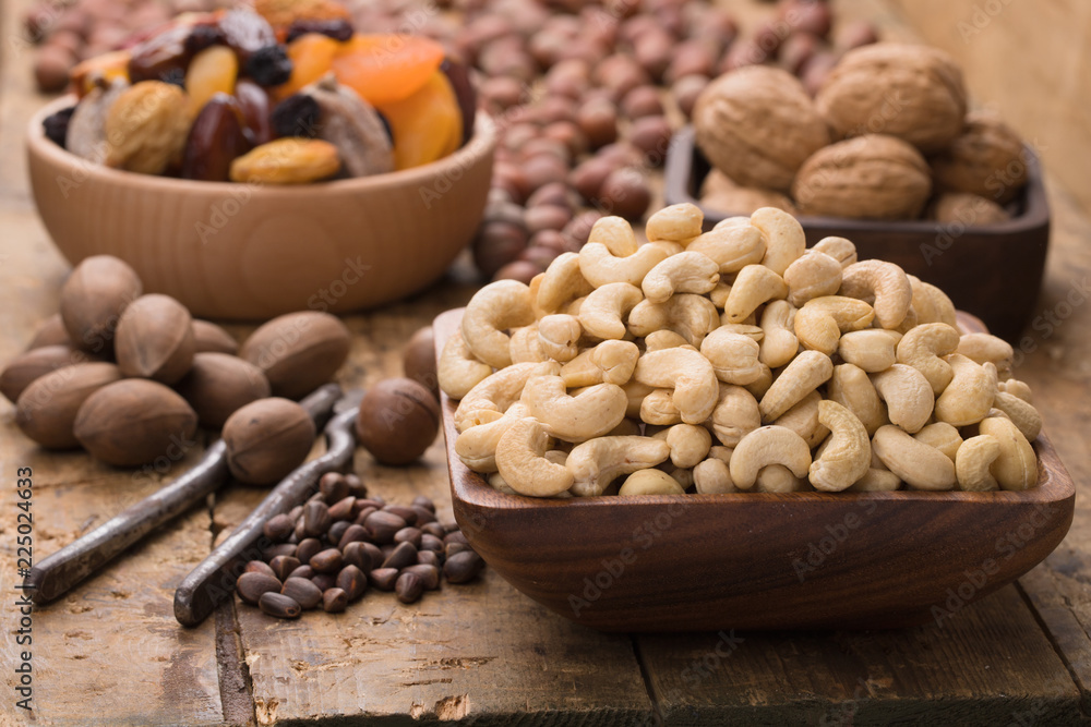 cashew nuts peeled raw in wooden bowl on table, grunge style. cashew nuts peeled raw in wooden bowl on table, grunge style.