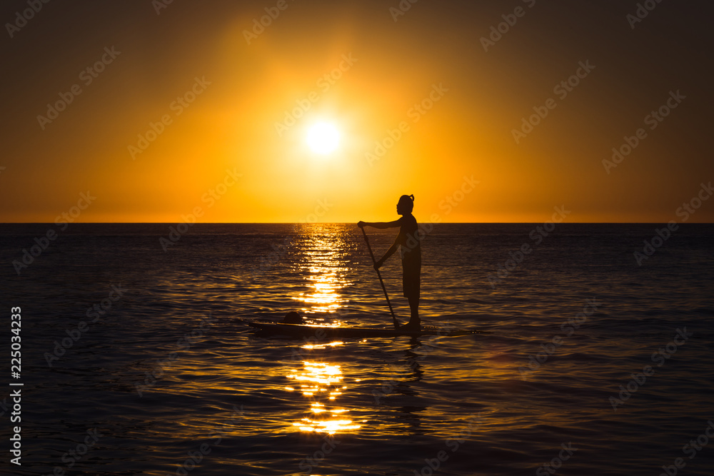 Silhouette of a man practicing stand-up paddle