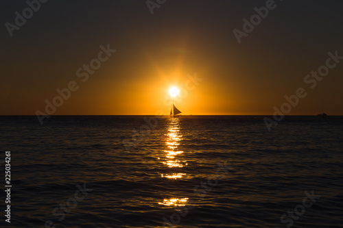 One outrigger sailboat on the horizon