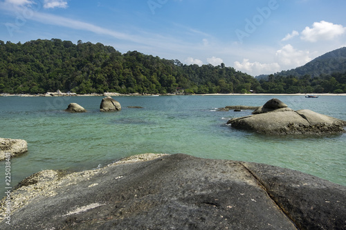 Scenic beach with island,rocks and turquoise sea water against sky in Pangkor island, Malaysia