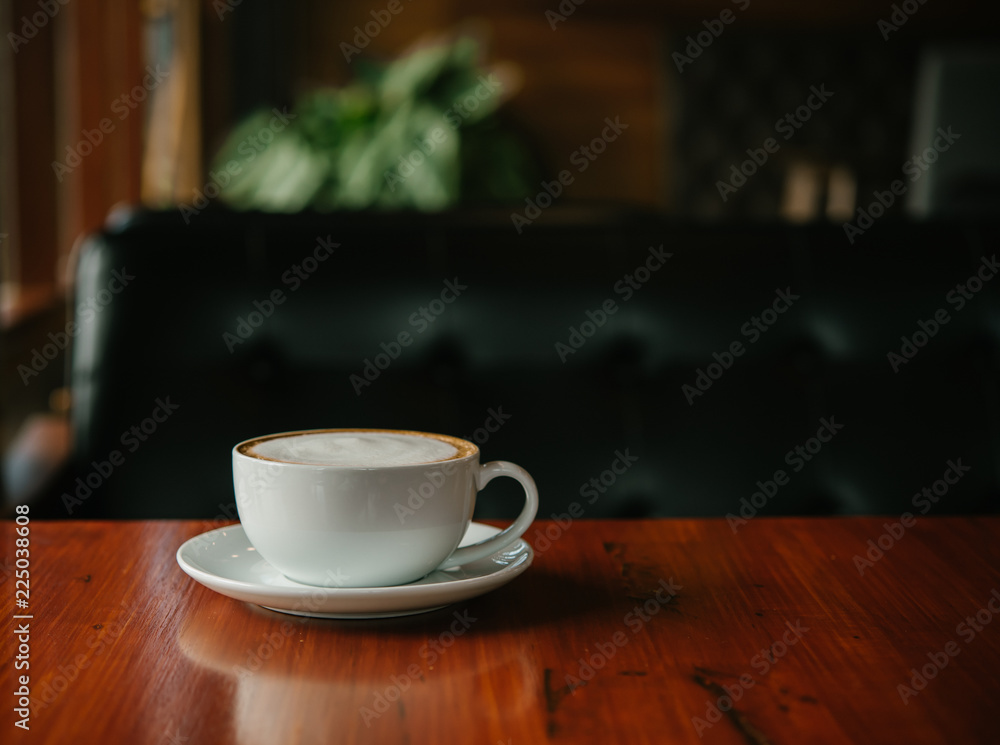 Hot Coffee in a cup on wooden table and morning light