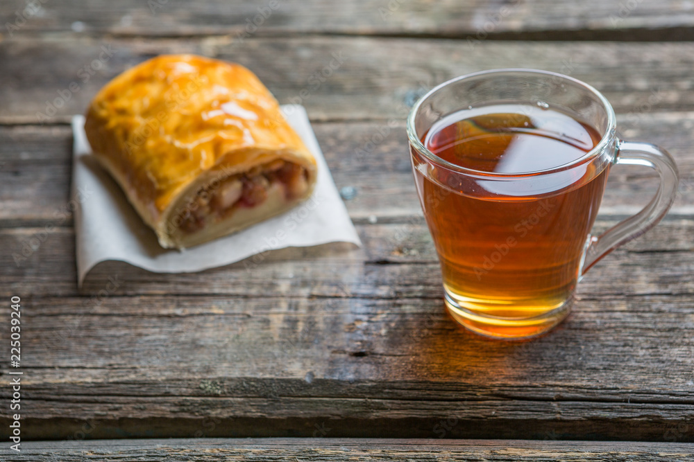 Apple strudel on wooden board served with tea Apple strudel on wooden board served with tea