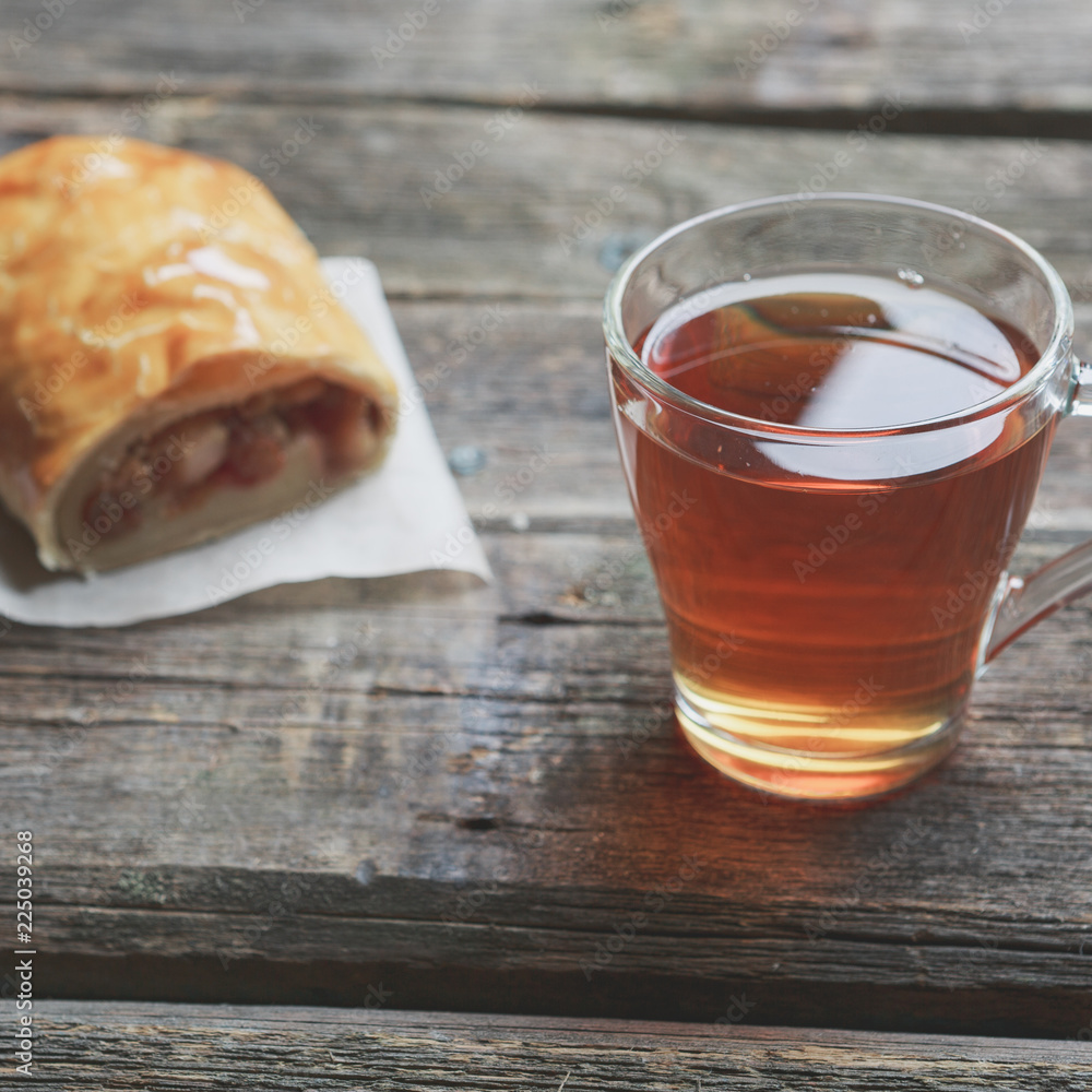 Apple strudel on wooden board served with tea Apple strudel on wooden board served with tea