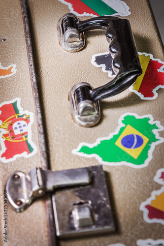 old suitcase with stickers of flags of the of traveling around