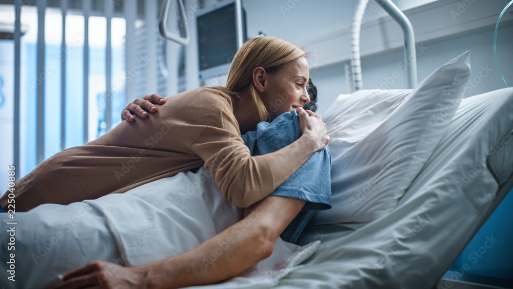 © Gorodenkoff - In the Hospital, Happy Wife Visits Her Recovering Husband who is Lying on the Bed. They Lovingly Embrace and Smile. © Gorodenkoff - In the Hospital, Happy Wife Visits Her Recovering Husband who is Lying on the Bed. They Lovingly Embrace and Smile.
