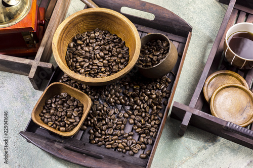 Coffee beans in a wooden Bowl on the wooden floor. © Sansert