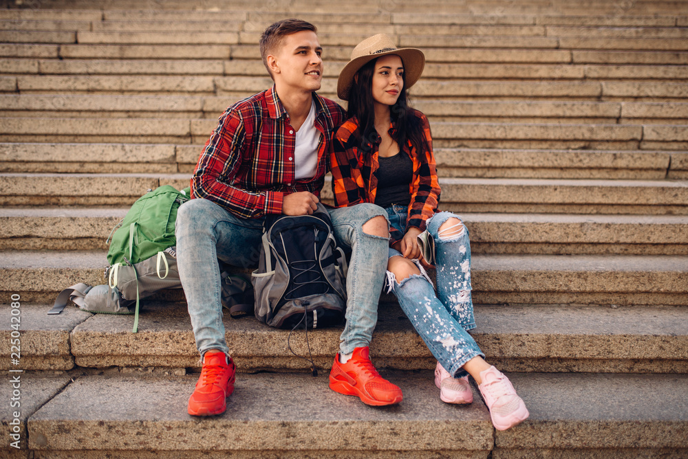 Tourists with backpacks resting on the stone steps Tourists with backpacks resting on the stone steps