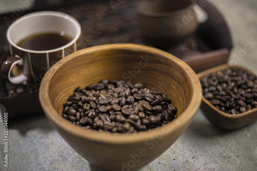 Coffee beans in a wooden Bowl on the wooden floor.