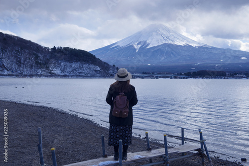 Woman is looking at Mt/ Fuji view at Lake Kawakuchiko in Japan during winter.