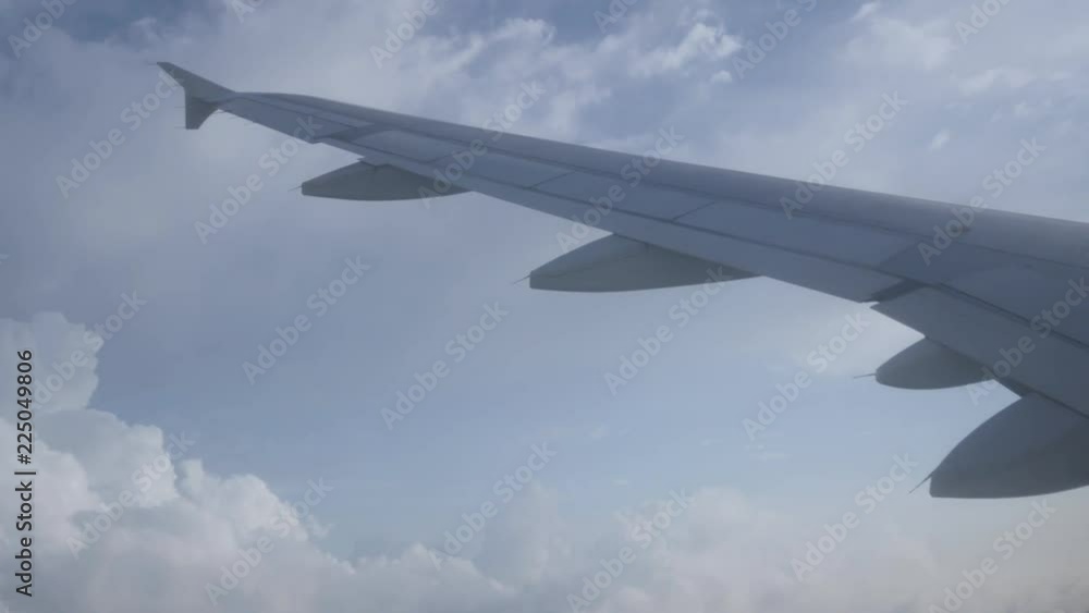 Landscape view of cloud and the sun from the inside plane's cabin (see plane's wing) while plane is turning in the sky Landscape view of cloud and the sun from the inside plane's cabin (see plane's wing) while plane is turning in the sky
