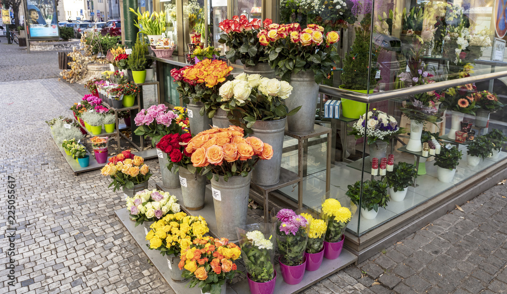 Small florist shop display with roses and chrysanthemums for sale.