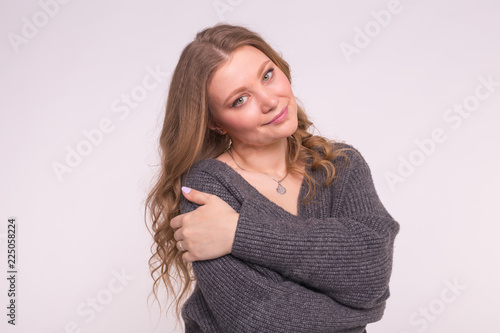 Close up portrait of caucasian tender woman with curly hair wearing gray cardigan on white background