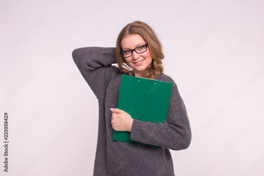 Beautiful student young woman in glasses holding green paper folder on white background Beautiful student young woman in glasses holding green paper folder on white background