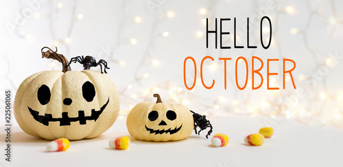 Hello October message with halloween pumpkins with spider on a shiny light background