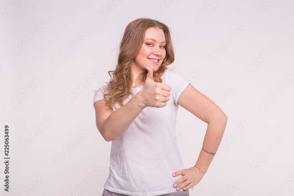 Fashion, style and gesture concept - pretty blonde woman showing thumbs up over white background Fashion, style and gesture concept - pretty blonde woman showing thumbs up over white background