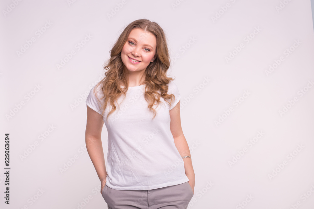 Young smiling woman posing over white background with copy space Young smiling woman posing over white background with copy space